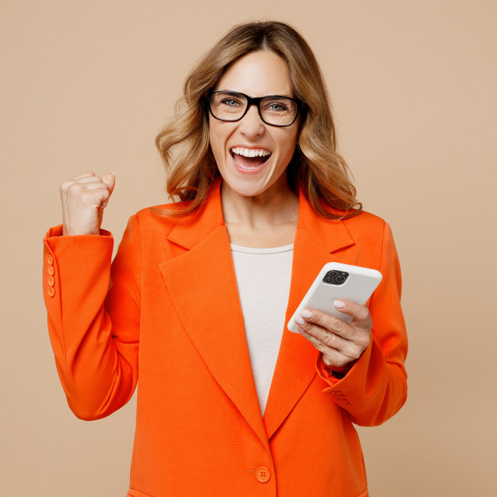 A woman in business attire celebrating a win.